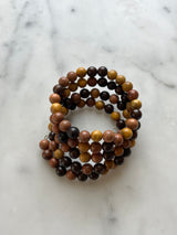 A beaded bracelet with a variety of brown and black beads